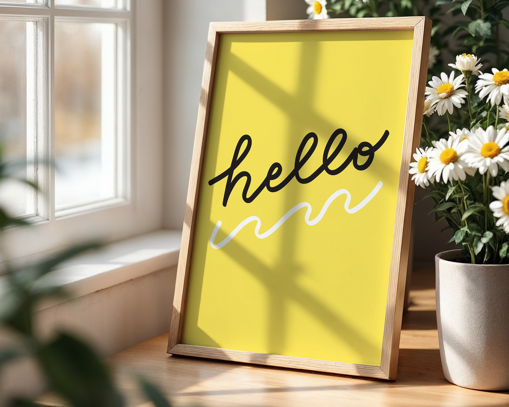 Framed yellow poster with 'hello' text designed by Kim Sabel Studio